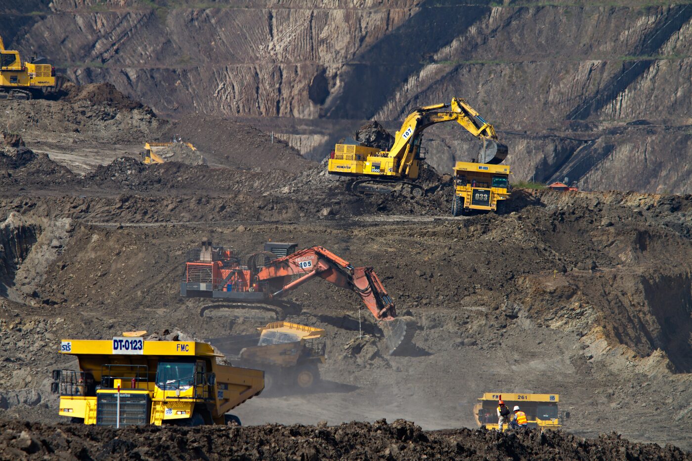 Haul trucks and excavators in an open-cut mine. Photo by Dominik Vanyi on Unsplash.