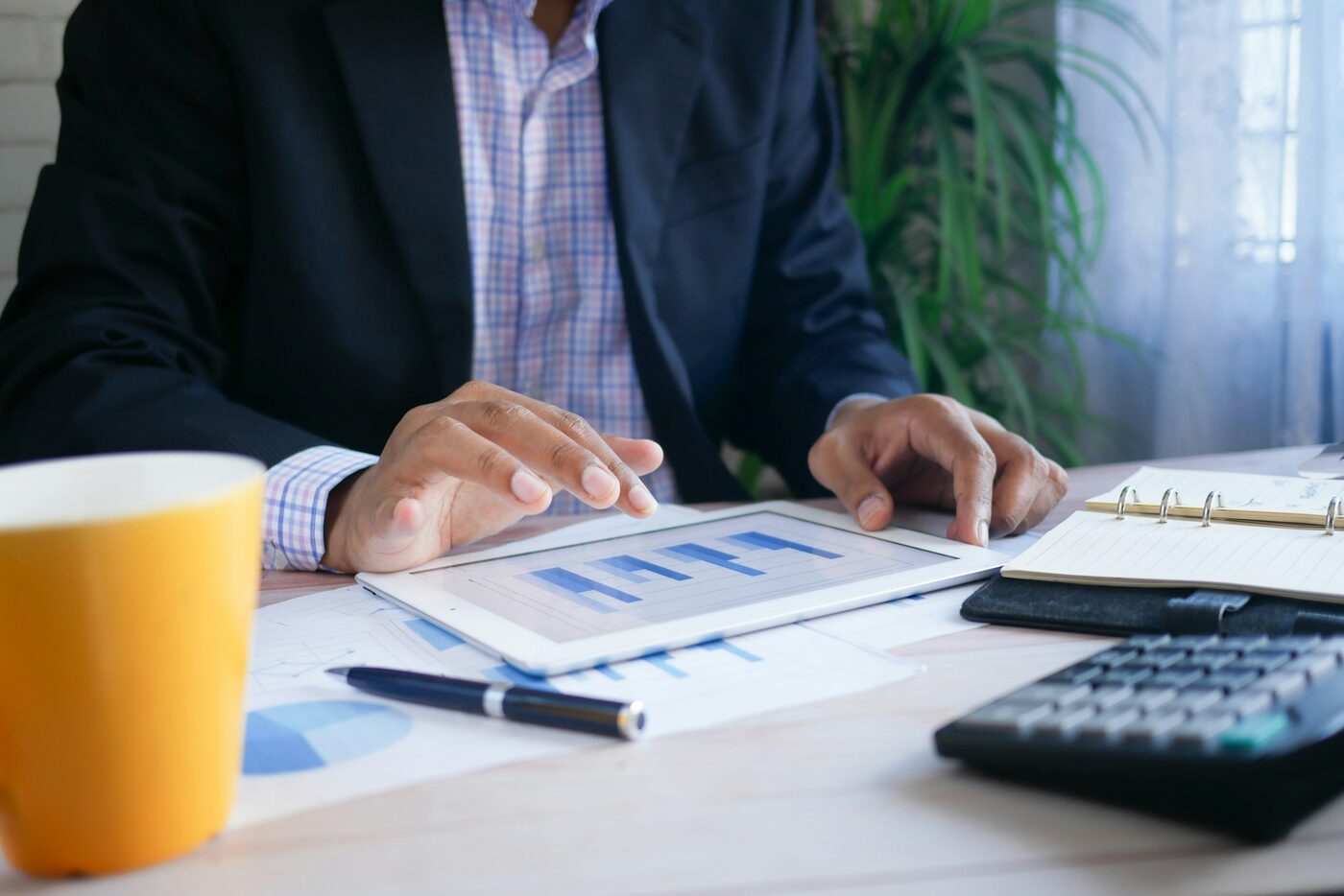 Finance professional reviewing reports at a desk. Photo by Towfiqu barbhuiya on Unsplash.